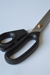 hand holding large metal scissors with black handle  ideal for themes like sewing, crafting,...