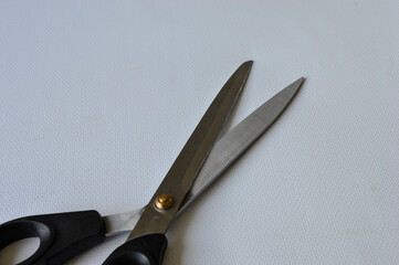 hand holding large metal scissors with black handle  ideal for themes like sewing, crafting,...