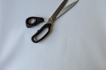hand holding large metal scissors with black handle  ideal for themes like sewing, crafting,...