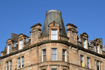 Old 19th Century Stone Building with Corner Cupola seen against Blue Sky 