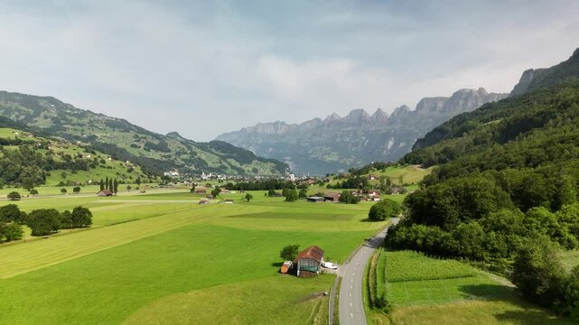 Scenic Aerial View of a Valley with Green Fields and Mountain Landscape in Switzerland near Flums, Berschis, and Walenstadt in the Canton of St. Gallen &ndash; Drone Footage