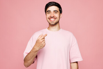 Young smiling fun man wearing t-shirt casual clothes hold in hand invisible transparent aligners,...