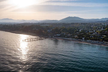
Marbella Sunset: Pier Reflections on the Mediterranean Coastline

An aerial view of Marbella's coastline at sunset, with sun glittering on the water, a pier extending into the sea, and mountains in t