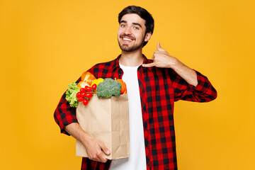 Young man wear casual clothes hold craft paper bag takeaway mock up with food products do phone...