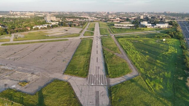Daytime aerial flying from start to end of Downsview (YZD) runway under clear blue sky, with Toronto skyline and CN Tower visible in the background