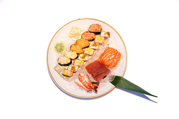 Assorted sushi platter with sashimi and nigiri on ice with leaf garnish and lime slice