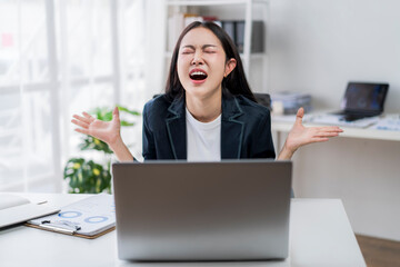 woman is sitting at a desk with a laptop open