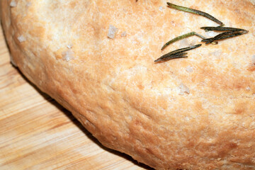 Close up of home made focaccia bread ready baked in the oven with rosemary