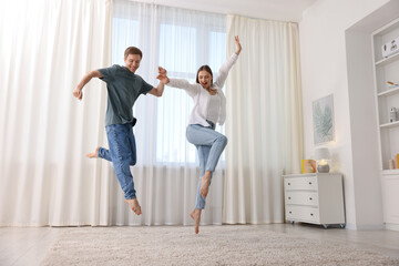 Happy young couple dancing together at home, low angle view