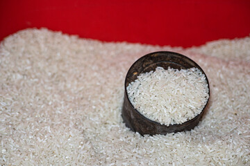 A measuring tin half buried in a pile of white rice