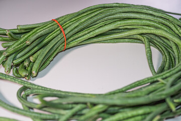 A bundle of fresh yardlong beans (Vigna unguiculata) isolated on white background
