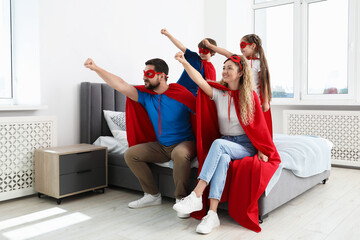 Parents and children in superhero costumes playing at home