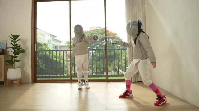 Before the tournament day, a boy and girl dressed in fencing gear are rehearsing in gym