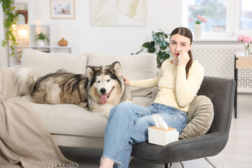 Woman suffering from allergy with her dog at home