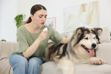 Woman suffering from allergy with her dog at home
