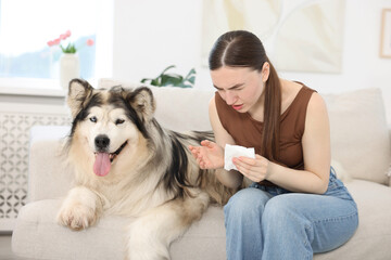 Woman suffering from allergy with her dog at home