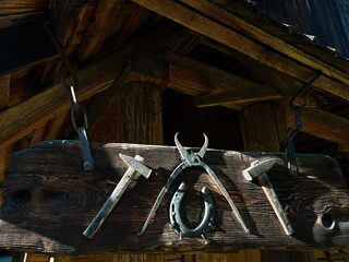 Hanging vintage blacksmith tools under a rustic timber roof structure