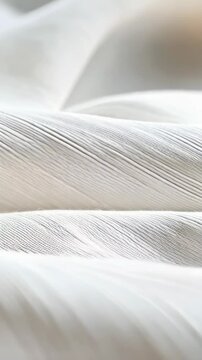 Close-up view of flowing white fabric with detailed parallel linear texture and soft curves, creating a smooth and elegant aesthetic.