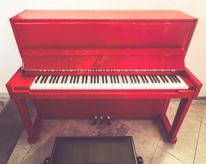 Front View of Red Upright Piano on Marble Floor
