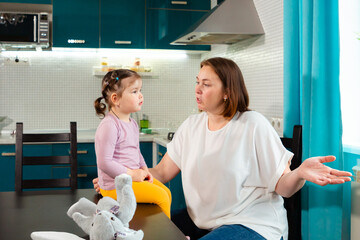 Mother and daughter enjoy cognitive toy playtime in kitchen. Concept of bonding, preschool...