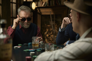 Serious determined man thinking about the course of the poker game in a vintage bar