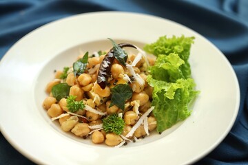 A bowl of fancy salad served on a white plate