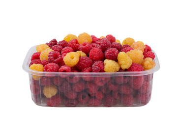 Yellow and red raspberries in plastic container isolated on white background.