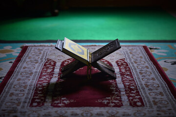 The Holy Alquran, holy book of Muslims and wooden prayer beads in a mosque