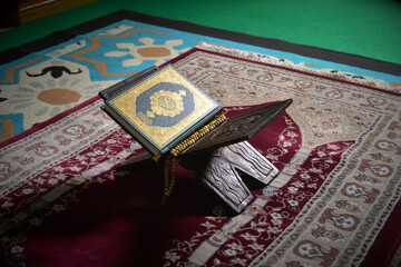 The Holy Alquran, holy book of Muslims and wooden prayer beads in a mosque