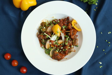 Szechuan Chicken which is a popular Indo-Chinese non vegetarian recipe. served in a plate with chilli sauce. selective focus