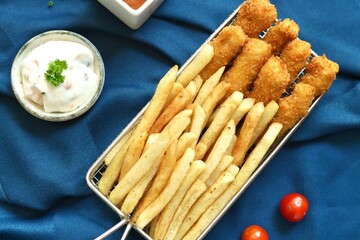 Fish and chips or french fries in a basket with mayonnaise 