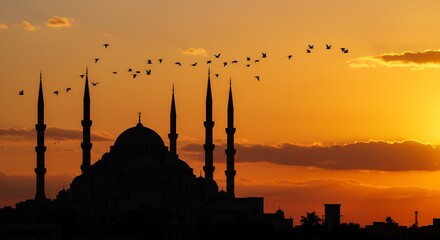 Fototapeta premium Silhouette of a Mosque with Flying Birds Against a Sunset Sky