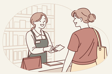 Smiling cashier handing receipt to customer at checkout in retail store