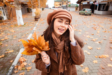 Weekend leisure in the city as a fashionable young woman moves through autumn scenes, soaking up...