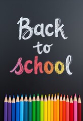 Chalkboard with Back to School message and a row of colorful pencils Education