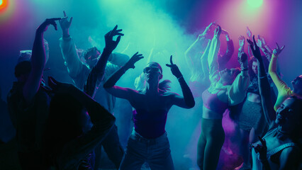 A vibrant party scene with diverse people dancing under colorful lights. Concept of nightlife...