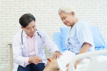 Orthopedic doctor checking on elderly woman knee.