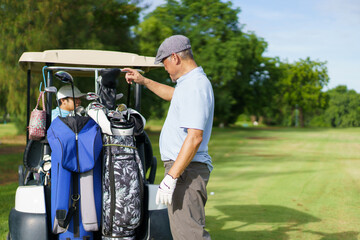 Asian man and elderly father are enjoy playing golf together with a good time.