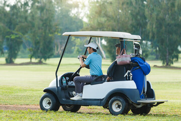 Asian man and elderly father are enjoy playing golf together with a good time.
