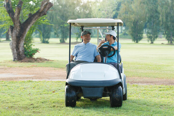 Asian man and elderly father are enjoy playing golf together with a good time.