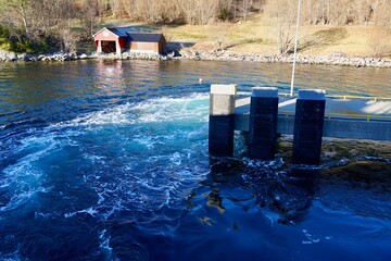 Strong current envelops a concrete pier as a car ferry maneuvers with its powerful side thrusters...