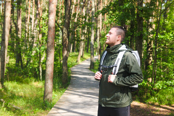 Man with a Backpack Hiking and Admiring Nature in a Lush Forest