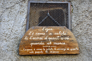 wooden sign with Genoese proverb: (translation) water is like health, you realize how much it is...