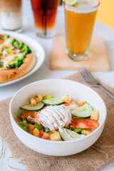 
Fresh vibrant salad with crisp vegetables, croutons, and creamy dressing, accompanied by pizza and drinks, perfect for a healthy and hearty meal.
