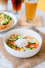 
Fresh vibrant salad with crisp vegetables, croutons, and creamy dressing, accompanied by pizza and drinks, perfect for a healthy and hearty meal.