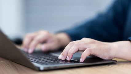 Closeup hand typing on laptop keyboard, business man working at office desk, using computer for online website management, technology tasks, and home office productivity