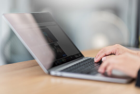 Business man using laptop for online work at home office, closeup hand typing on keyboard, modern technology desktop, website development, and computer desk setup