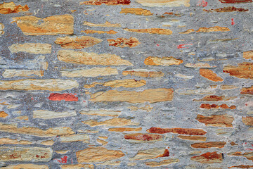 Old weathered sandstone wall forming a colorful textured background in Czech Republic