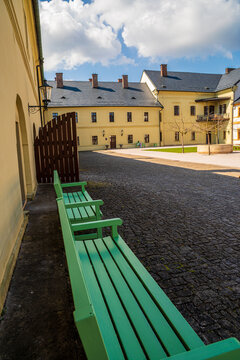 Green benches inviting to relax in the courtyard of Czech castle