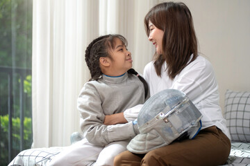 The mother of the girl fencer is taking care of her fencing gear. Caring for your growing child